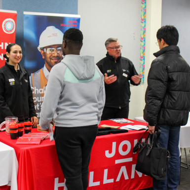 Attendees at the Industry Engagement Event at Melbourne Polytechnic's Preston Campus speak with representatives at the John Holland exhibition booth.