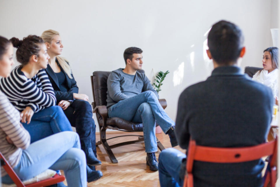 A group of people sitting in a circle and listening to one another talk