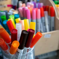 A large selection of coloured textas and sharpies in boxes and jars
