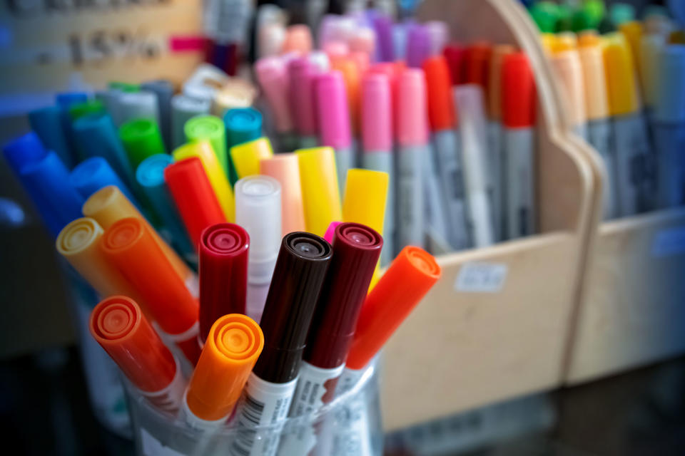 A large selection of coloured textas and sharpies in boxes and jars