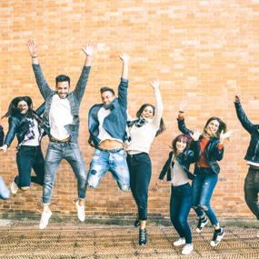 Image of smiling students jumping in the air 