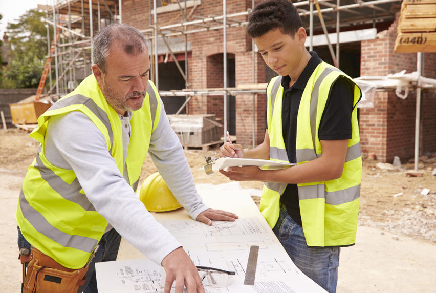Two construction workers interpreting technical papers