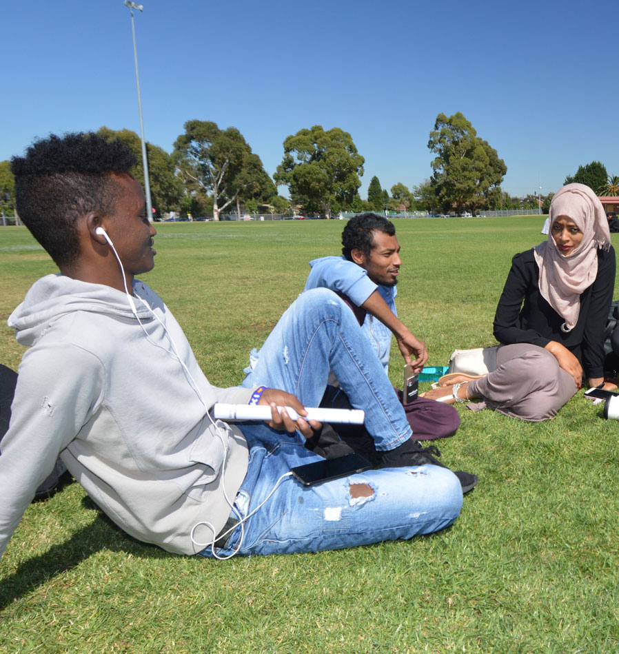 3 Students on lawn at Melbourne Polytechnic campus