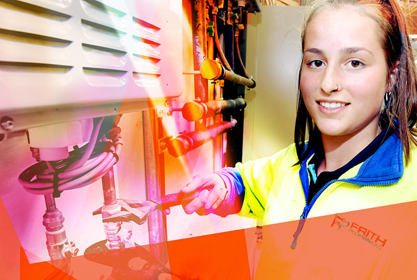 Women in trades - female plumber with wrench working on an airconditioning system
