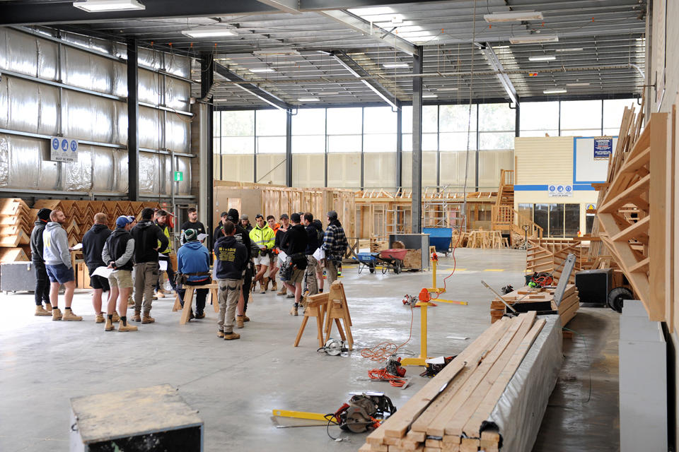 Building Surveying and Construction students gathered to listen to teacher in a Melbourne Polytechnic training shed